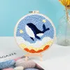 A punch needle embroidery kit featuring a whale design, displayed on a wooden easel. Produktbild-Vorschau