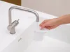 A hand is holding a white sink strainer under a running faucet. Anteprima dell’immagine prodotto