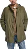 A man wearing a green parka and blue jeans.