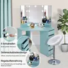 A light blue corner vanity desk with a lighted mirror, drawers, and shelves, shown with a white stool and a potted plant. Voir les images du produit