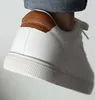 Close-up of the heel and side of a white sneaker with a brown leather accent. Voir les images du produit