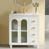 A white bathroom vanity with a gold faucet and a mirror above it, set against a yellow wall. Produktbild-Vorschau