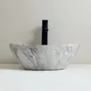 A close-up studio shot of a marble-patterned vessel sink with a black faucet. Náhľad obrázku produktu