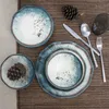 A table setting with plates, cutlery, and a glass on a placemat. Voir les images du produit