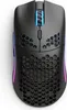 A top-down view of a black gaming mouse with honeycomb cutouts and RGB lighting. Podgląd zdjęcia produktu