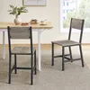 Two dining chairs are shown in a dining room setting next to a table. Náhled obrázku produktu