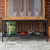 A mini greenhouse on a shelf with gardening tools and a bag of soil. Voir les images du produit