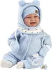 A baby doll dressed in a blue outfit with a hat and mittens, sitting down. Produktbild-Vorschau