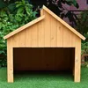 A wooden dog house or shelter is shown outdoors on a green lawn with foliage in the background. Voir les images du produit