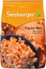 A bag of popcorn with a bowl of popcorn in the foreground. Produktbild-Vorschau