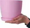 Hands holding a pink flower pot with a saucer. Náhled obrázku produktu