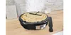 A crepe maker with a crepe being cooked on it, placed on a wooden countertop with a backsplash of stone tiles. Produktbild-Vorschau