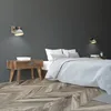 A bedroom scene with a bed, nightstand, and wall lamps. Anteprima dell’immagine prodotto