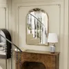 A decorative mirror above a fireplace mantelpiece with a lamp and books. Podgląd zdjęcia produktu
