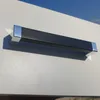 A close-up shot of a black cabinet handle with silver ends attached to a light gray surface. Podgląd zdjęcia produktu