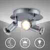 A silver-colored ceiling spotlight with three adjustable heads is shown mounted on a white ceiling. Voir les images du produit
