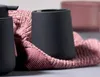 A black soap dispenser and a black toothbrush holder sit on a pink knitted towel. Produktbild-Vorschau