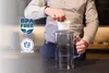 A person is inserting a filter into a glass water pitcher. Produktbild-Vorschau