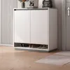A modern shoe cabinet with two doors and an open lower shelf displaying shoes. Náhled obrázku produktu