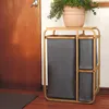 A laundry basket with three compartments is placed next to a wooden door, with a potted plant on top. Produktbild-Vorschau