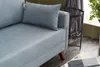 A close-up view of a blue sofa with a pillow, showing its fabric texture and wooden legs. Produktbild-Vorschau
