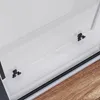 A close-up view of a shower enclosure's sliding door mechanism, showing the black rollers and tracks against a white background and a wooden floor. Produktbild-Vorschau