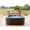 A couple relaxing in an inflatable hot tub on a patio. Voir les images du produit