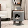 A cat is playing inside a cat house with a toy. The cat house is placed in a living room setting next to a sofa and a bookshelf. Náhľad obrázku produktu