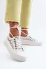 A person wearing white lace sneakers with yellow pants. Voir les images du produit