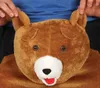 A close-up of a person's hands holding the ears of a plush teddy bear costume. Anteprima dell’immagine prodotto