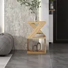 A modern living room scene featuring a wooden side table with decorative items and books. Produktbild-Vorschau