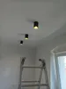 Three black cylinder-shaped ceiling lights are installed on a white ceiling. A silver ladder is positioned in the foreground, leaning against a white wall. A window with white trim is visible on the right side of the image. Náhľad obrázku produktu