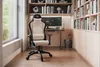 A gaming chair is placed in a home office setting with bookshelves and a window. Produktbild-Vorschau
