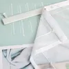 A close-up view of a white sheer curtain with a velcro strip, laid over a light green background with text. Produktbild-Vorschau
