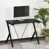 A black gaming desk with a silver computer monitor on it, placed against a white wall with a potted plant to the right. Podgląd zdjęcia produktu