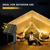 A person sits inside a tent illuminated by solar-powered LED string lights, with a solar panel visible outside. Náhľad obrázku produktu