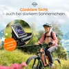 A woman riding an e-bike in a grassy, mountainous landscape, with a close-up of the bike's display. Produktbild-Vorschau
