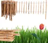 A wooden fence and a tulip in grass. Produktbild-Vorschau