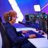 A young person is gaming and streaming in a room with colorful lighting. Produktbild-Vorschau