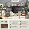 A home office setup featuring a large corner desk with two monitors, a chair, and storage shelves. Produktbild-Vorschau