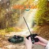 A remote-controlled tank toy is being operated by a person in a forest setting. Anteprima dell’immagine prodotto