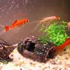 A close-up view of an aquarium with fish swimming around a decorative log. Produktbild-Vorschau