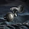 Three metal cabinet knobs are arranged on a textured dark blue fabric, resembling denim. Produktbild-Vorschau