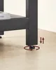 Close-up of a table leg with an adjustable foot, showing how it can be screwed in or out to level the table. An illustration indicates up and down movement and rotation. Náhled obrázku produktu