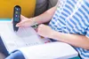 A person is using a scanning pen to read a book. Produktbild-Vorschau