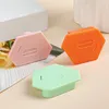 Three hexagonal magnetic seam guides in pink, orange, and green are displayed on a surface with a blurry background. One is slightly in front of the other two. Produktbild-Vorschau