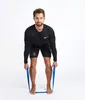 A man is performing a fitness exercise with a resistance band. Podgląd zdjęcia produktu