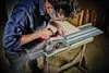 A man is using a circular saw with a guide rail to cut a piece of wood. Produktbild-Vorschau