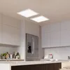 A modern kitchen with white cabinets, a stainless steel refrigerator, and a kitchen island. Produktbild-Vorschau
