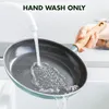 A hand is washing a frying pan under running water in a sink. Náhled obrázku produktu